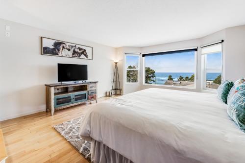 Un dormitorio con una cama grande y una ventana grande en The White Anchor, en Depoe Bay