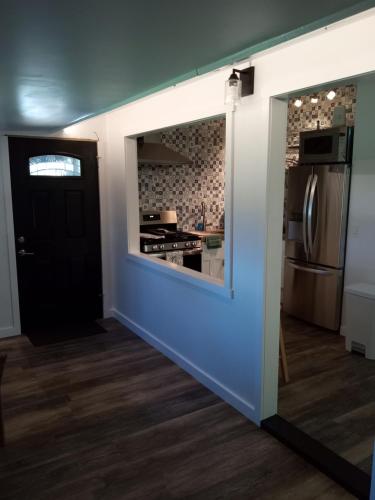 a room with a kitchen with a black door at Hawaii Getaway in Holualoa