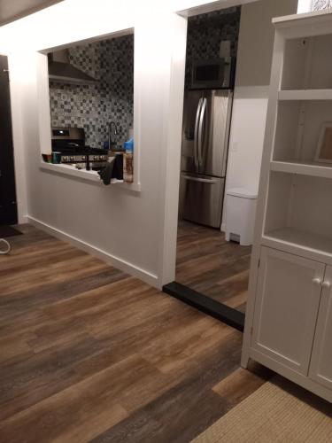 a living room with a mirror and a kitchen at Hawaii Getaway in Holualoa
