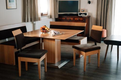 a table and chairs with a bowl of fruit on it at Ferienwohnung Birkentalblick in Nesselwängle