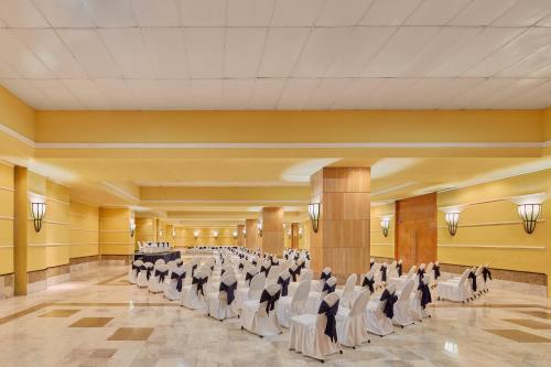 a large banquet hall with white chairs and tables at Copacabana Beach Hotel Acapulco in Acapulco