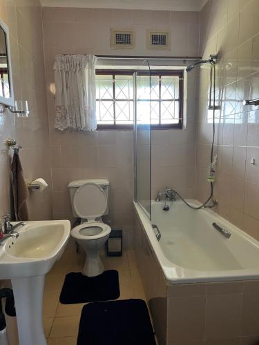a bathroom with a tub and a toilet and a sink at Apt 66 Eden Wilds Umtamvuna Getaway in Port Edward