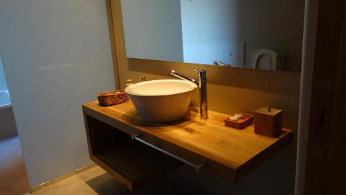 a bathroom with a bowl sink and a mirror at Casa de Huéspedes La Azul in Los Árboles