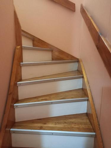 una escalera en una casa de madera y blanco en Lo de Elena en Ushuaia