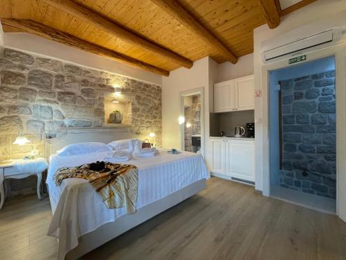 ein Schlafzimmer mit einem Bett und einer Steinmauer in der Unterkunft Dubrovnik Throne Suite IV in Dubrovnik