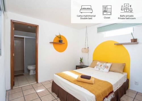 a bedroom with a bed and a bathroom with a toilet at Hostal La Paz & Love Guadalajara in Guadalajara