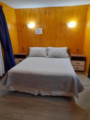 - une chambre avec un grand lit et des murs en bois dans l'établissement nancy, à Pucón