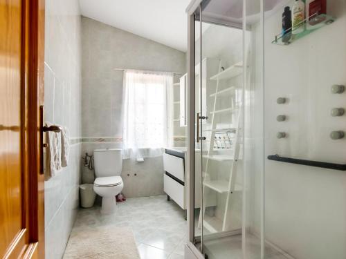 a bathroom with a toilet and a glass shower at Spacious holiday home in Santiago de Compostela with pool in Eirapedriña