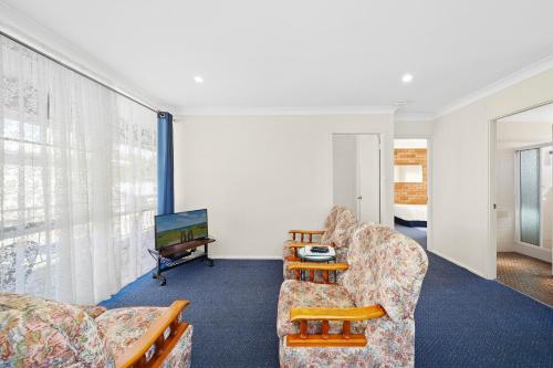 a living room with two chairs and a television at Sundial Holiday Units in North Haven