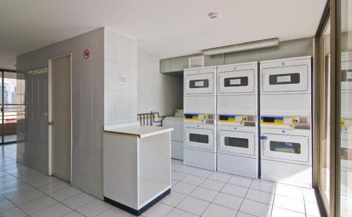 a kitchen with white appliances in a room at Park Plaza Apart Hotel in Santiago