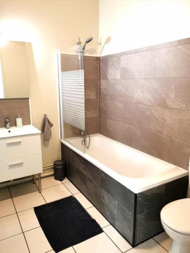 une salle de bain avec une baignoire, des toilettes et un lavabo dans l'établissement Charmant studio proximité centre-ville et gare, à Châlons-en-Champagne