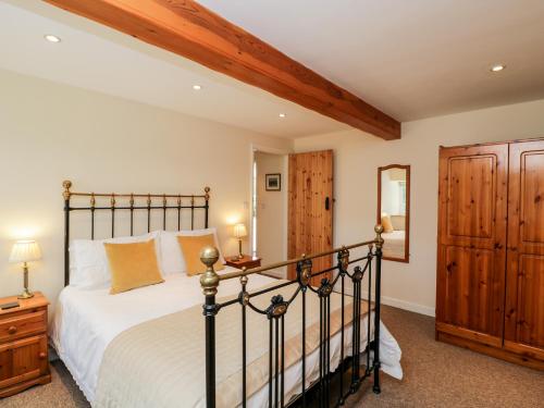 Un dormitorio con una cama grande y un armario de madera. en The Old School Room, en Chelborough