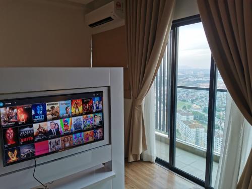 a flat screen tv in a room with a large window at Apple Home 1 @ Menara Simfoni/Symphony Tower C180/Cheras/Mines/Balakong/Kuala Lumpur in Seri Kembangan