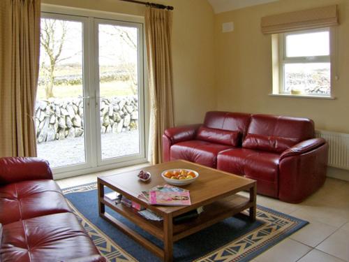 a living room with a couch and a coffee table at Dolmen Cottage in Kilfenora