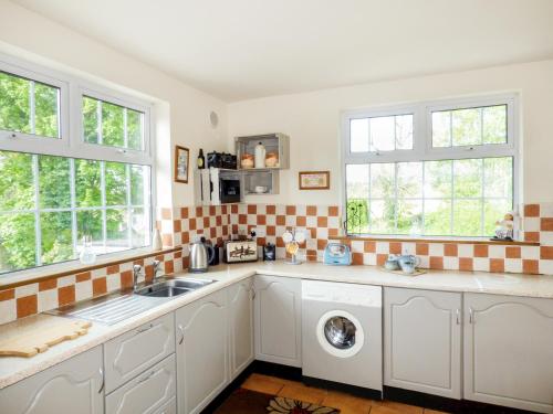 a kitchen with a sink and a washing machine at Berrylane in Enniscorthy