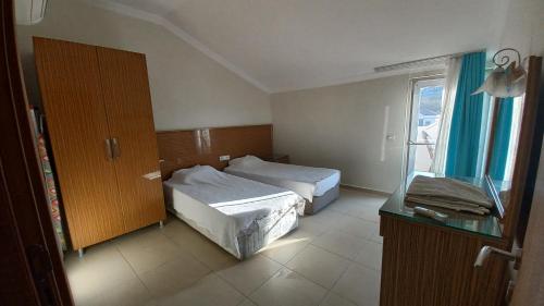 una camera d'albergo con due letti e una finestra di Mediterranean apart hotel a Fethiye