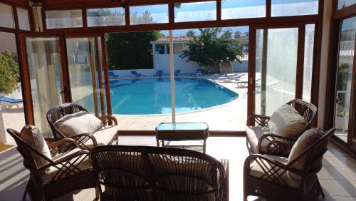 un porche cubierto con sillas y piscina en Mediterranean apart hotel, en Fethiye