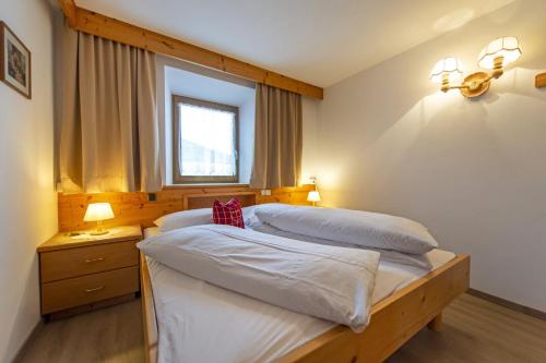 a bedroom with two beds and a window at Chalet Alpina in Ortisei