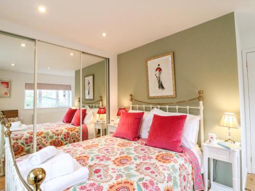 a bedroom with two beds and a mirror at Little Retreat in Upwey