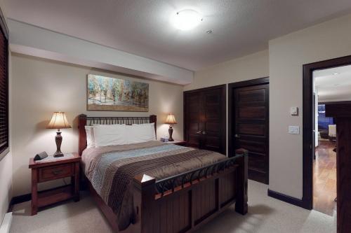 a bedroom with a bed and two lamps on tables at Aspens 3308 in Big White