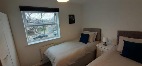a bedroom with two beds and a window at Hawksworth House, Birmingham Near NEC, HS2, Jaguar Land Rover, Bear Grylls Centre, Resorts World and Birmingham airport with a garage and free allocated parking in Kingshurst