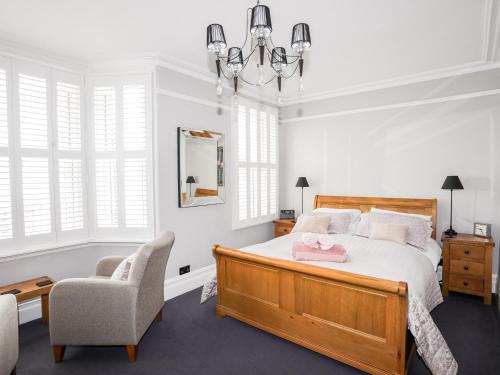 a bedroom with a bed and a chair at Maelgwyn in Criccieth