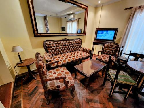 a living room with a couch and chairs and a tv at Tradición de Salta in Salta