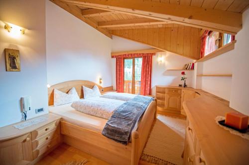 ein Schlafzimmer mit einem großen Bett in einem Zimmer in der Unterkunft Chalet Prinoth in Wolkenstein in Gröden
