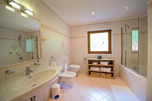 Un baño con bañera, inodoro y lavabo. en Chalet Prinoth, en Selva di Val Gardena
