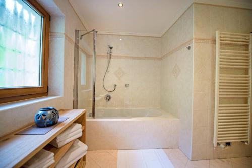 a bathroom with a bath tub and a shower at Chalet Prinoth in Selva di Val Gardena