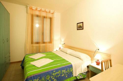 a bedroom with a green and white bed and a window at Residence Solaria, Lido Adriano in Lido Adriano