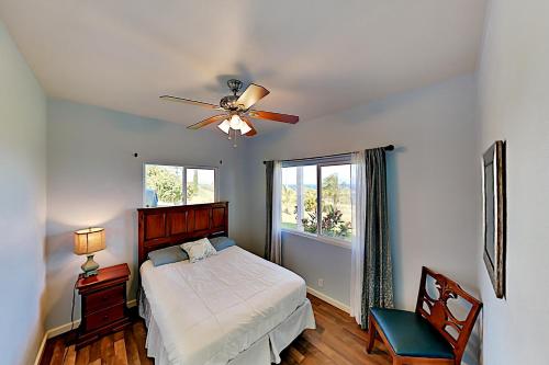 a bedroom with a bed and a ceiling fan at Big Island Getaway, Ocean View Paradise in Ninole