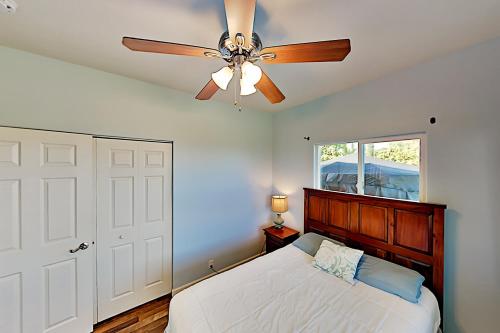 a bedroom with a ceiling fan and a bed at Big Island Getaway, Ocean View Paradise in Ninole