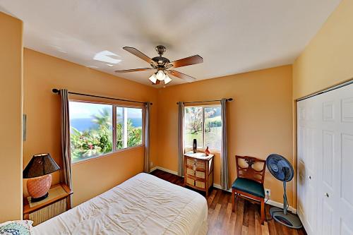 a bedroom with a bed and a ceiling fan at Big Island Getaway, Ocean View Paradise in Ninole