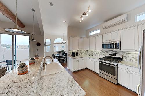 a kitchen with white cabinets and a counter top at Shalako Adventures in Santa Fe