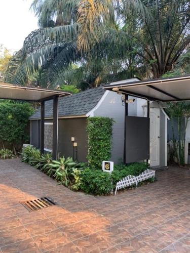 a house with a pavilion and a brick patio at Kurina Hotel in Bangkok