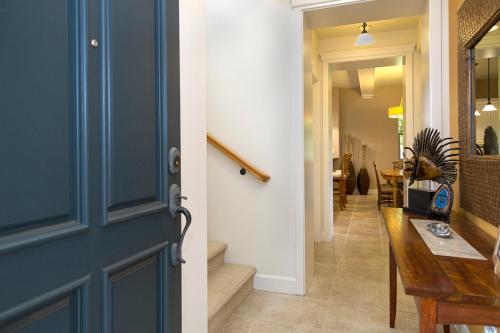 a hallway with a blue door and a hallway with a table at Mauna Lani 2002 in Waikoloa
