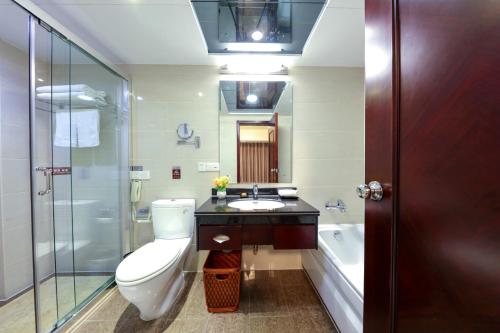 a bathroom with a toilet and a sink and a tub at Sanyu Hotel in Guangzhou