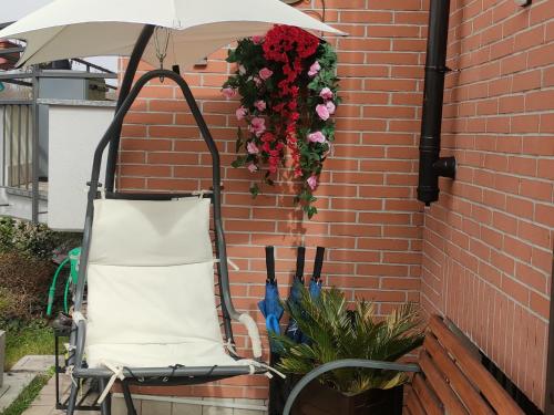 a chair under an umbrella next to a brick wall at New Home in Ferno