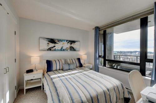 a bedroom with a bed and a large window at The Astoria Flair in Victoria