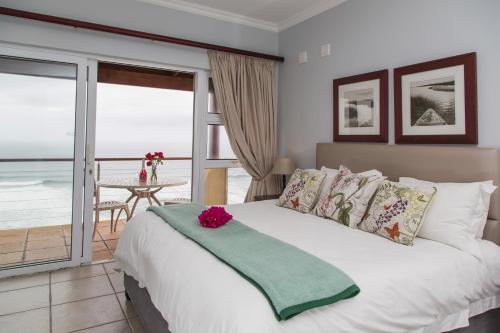 a bedroom with a bed with a view of the ocean at Sea View 3 bedrooms Villa in Brenton On The Rocks in Brenton-on-Sea