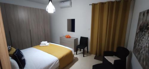 a bedroom with a bed and a desk and chairs at Searenity in Marsaxlokk