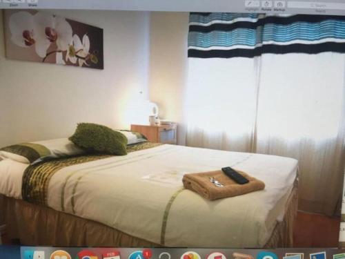 a bedroom with a bed with a towel on it at Family Room Sleeps 3 with 1 double and 1 single bed Ground Floor Private shower in Hayes