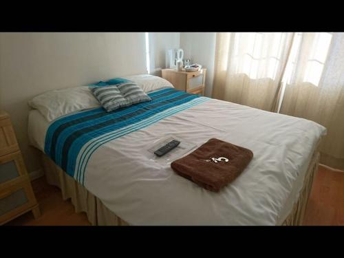 a bed with a towel and a remote control on it at En suite shower room Double room with 1 double deyr in Hayes