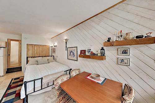 Schlafzimmer mit einem Bett und einem Tisch in der Unterkunft Sierra Del Sol 23 in Taos Ski Valley