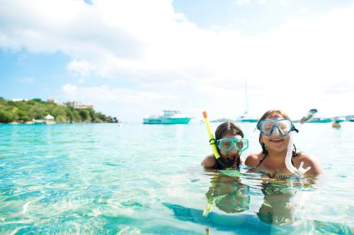 a woman and child wearing goggles in the water at Secret Harbour Beach Resort in St Thomas
