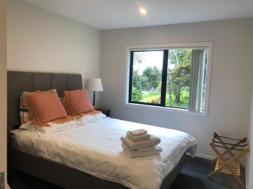 a bedroom with a large bed with a window at Aroma House in Pokeno
