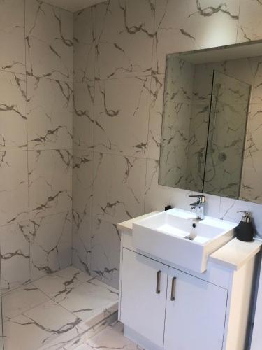a bathroom with a white sink and a mirror at Aroma House in Pokeno