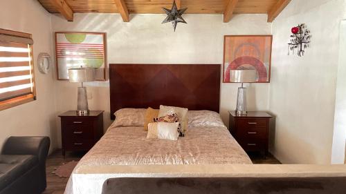 1 dormitorio con 1 cama grande, 2 mesas y 2 lámparas en Cabañas Yasmina, en Mazamitla
