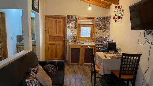 sala de estar con mesa y cocina en Cabañas Yasmina, en Mazamitla